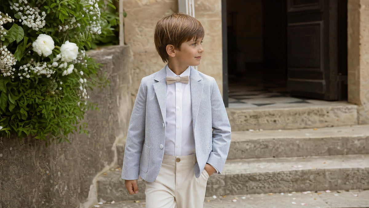 Garçon en tenue de cérémonie avec accessoires adaptés pour un mariage. Afbeelding